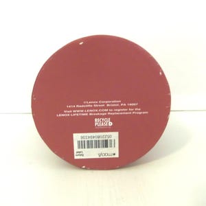 May include: A circular red base with white text reading Lenox Corporation, 1414 Radcliffe Street, Bristol, PA 19007, and information about the Lenox Lifetime Breakage Replacement Program. It includes a barcode and a Macy's return label.