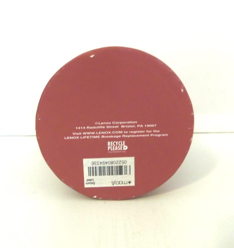 May include: A circular red base with white text reading Lenox Corporation, 1414 Radcliffe Street, Bristol, PA 19007, and information about the Lenox Lifetime Breakage Replacement Program. It includes a barcode and a Macy's return label.