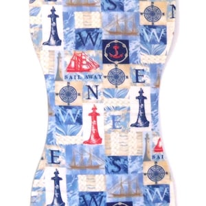 May include: A nautical-themed baby burp cloth with a patchwork design. The cloth features blue and white squares with images of lighthouses, sailboats, compasses, and the words "SAIL AWAY". The cloth is shaped to fit over the shoulder.