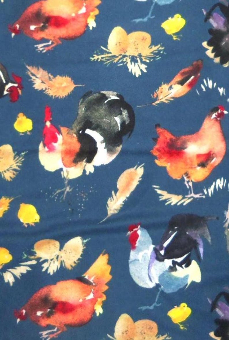 May include: Watercolor fabric with a navy blue background featuring roosters, hens, chicks, nests with eggs, and feathers. The roosters and hens are in shades of red, orange, black, and blue. The chicks are yellow, and the feathers are tan.
