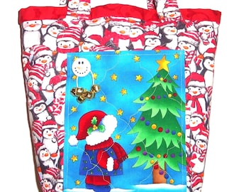 Könnte beinhalten: Eine gesteppte Stofftasche mit einem sich wiederholenden Muster aus Pinguinen, die rote und weiße Wintermützen und Schals tragen. Eine blaue Vordertasche zeigt eine Grafik einer Figur mit roter Mütze vor einem geschmückten Weihnachtsbaum.