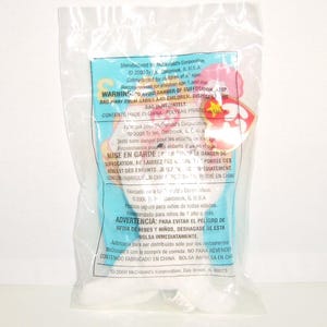 May include: A plush toy sealed in a clear plastic bag with a light blue label featuring text in English, French, and Spanish. The label includes the Ty logo, McDonald's Corporation branding, and safety warnings dated 2000. The toy is partially visible inside the packaging, showing white fabric and a red heart-shaped tag.