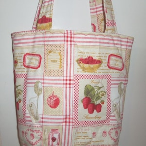 May include: A quilted tote bag featuring a cream-coloured fabric with a red plaid grid pattern. The print includes illustrations of strawberries, jars of jam, sugar canisters, spoons, and text related to strawberry jam recipes and ingredients.