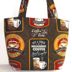 Puede incluir: Un bolso tote acolchado de color marr&oacute;n oscuro con un patr&oacute;n repetitivo de tem&aacute;tica cafetera. El estampado incluye varias tazas de caf&eacute;, granos y textos como "Coffee Time", "House Blend" y "Hot & Fresh Morning Coffee Served Everyday".