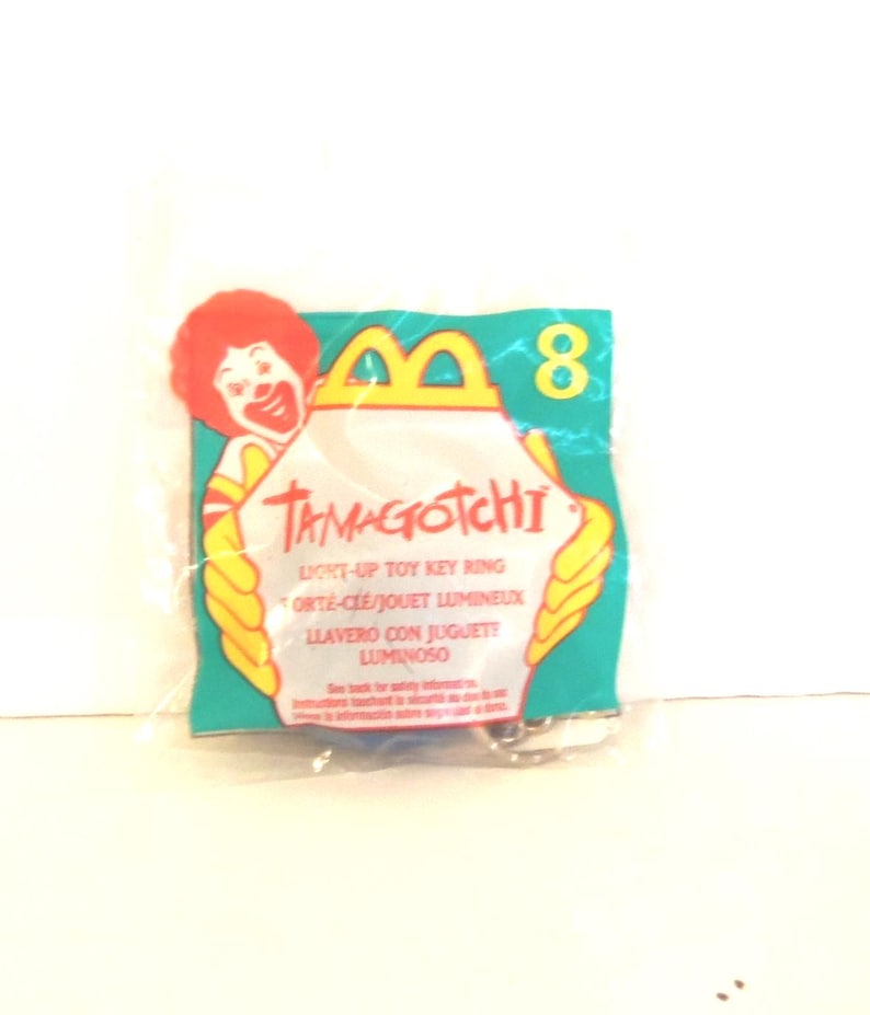 Puede incluir: Una bolsa de pl&aacute;stico sellada que contiene un llavero de juguete luminoso Tamagotchi. El empaque presenta un gr&aacute;fico de Ronald McDonald, el n&uacute;mero 8 y el texto Tamagotchi, Light-Up Toy Key Ring, Porte-Cl&eacute;/Jouet Lumineux y Llavero Con Juguete Luminoso.