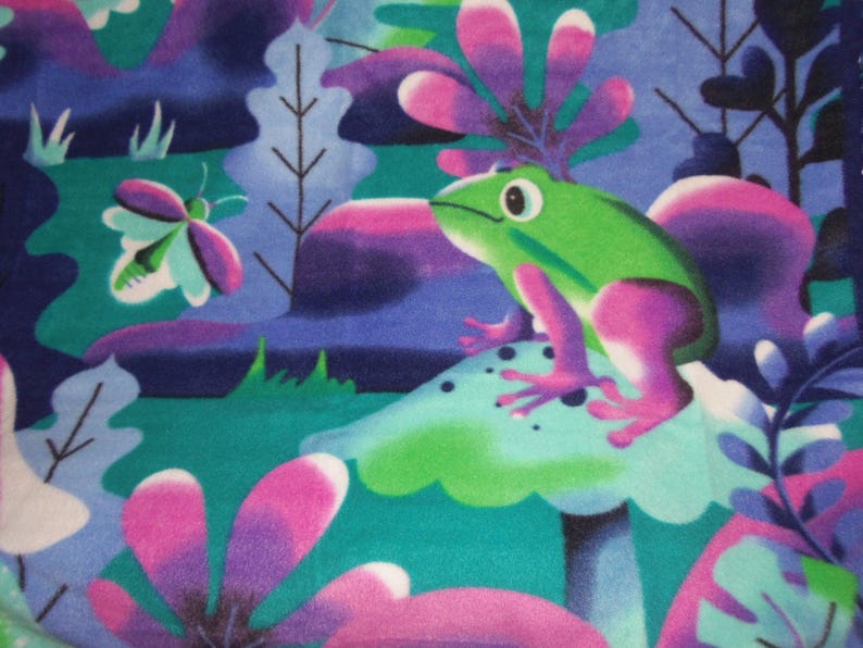 May include: A colourful illustration of a green frog with pink details, sitting on a mushroom. The background features stylized plants, a butterfly, and a palette of teal, purple, and blue, creating a whimsical, fantasy-themed design.