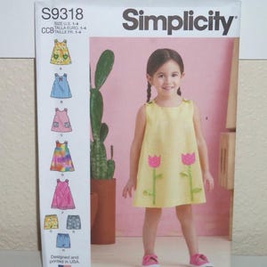 May include: A Simplicity sewing pattern envelope S9318 for sizes 1-4. The front shows a yellow gingham sleeveless dress with pink tulip appliqu&eacute;s. The left side displays illustrations of eight different dress and shorts variations with labels A through H.