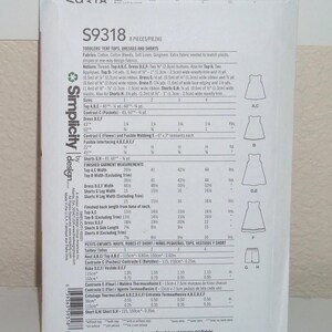 May include: A white Simplicity sewing pattern envelope S9318 for toddlers' tent tops, dresses, and shorts. The back of the envelope displays technical information, fabric requirements, size charts in metric, and line drawings of the garments.