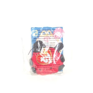 May include: A red and black plush toy sealed in a clear plastic bag. The packaging features the Ty logo and printed text including Manufactured for McDonald's Corporation, 2000 Ty Inc., and recommended for children age 1 and over.