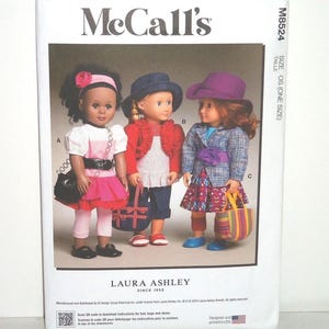 May include: McCall's sewing pattern featuring three dolls in Laura Ashley outfits. The dolls wear dresses, jackets, and hats, with accessories like purses and a belt. The pattern includes instructions for belts, bags, and shoes.
