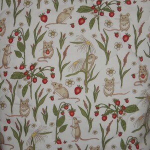 May include: A white fabric featuring a repeating pattern of light brown mice, red strawberries, green leaves, and white daisy flowers. The quilted material displays various illustrations of mice interacting with the plants and fruit in a natural setting.