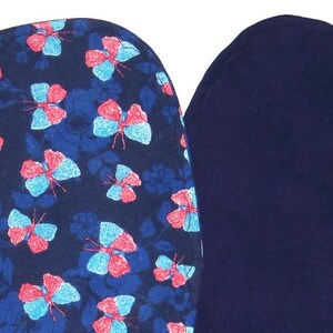 May include: Two fabric squares, one with a blue background and a pattern of pink and blue butterflies, and the other a solid dark blue.