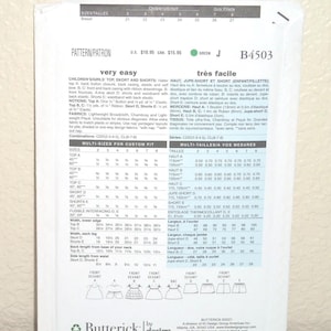 May include: A white Butterick sewing pattern envelope B4503 for children's and girls' tops, skorts, and shorts. The back of the envelope displays technical illustrations, sizing charts in inches, fabric requirements, and instructions in English and French.