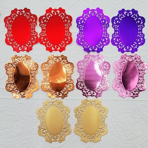 May include: A collection of oval-shaped decorative embellishments in various colors, including red, purple, gold, and pink. Each piece features a detailed, openwork filigree border. These craft supplies are ideal for scrapbooking and card making.