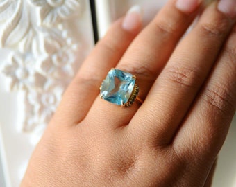 Anillo Isabella Blue Topaz con bisagras tachonadas de diamantes azules en los lados