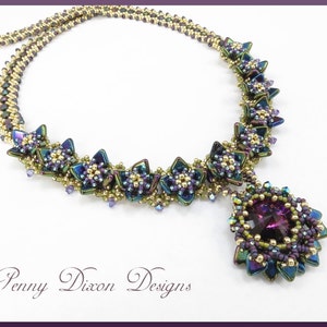 May include: A multi-strand beaded necklace with a large purple pendant. The necklace is made with gold, green, and purple beads. The pendant is a cluster of beads with a large purple crystal in the center. The necklace is called "Penny Dixon Designs".