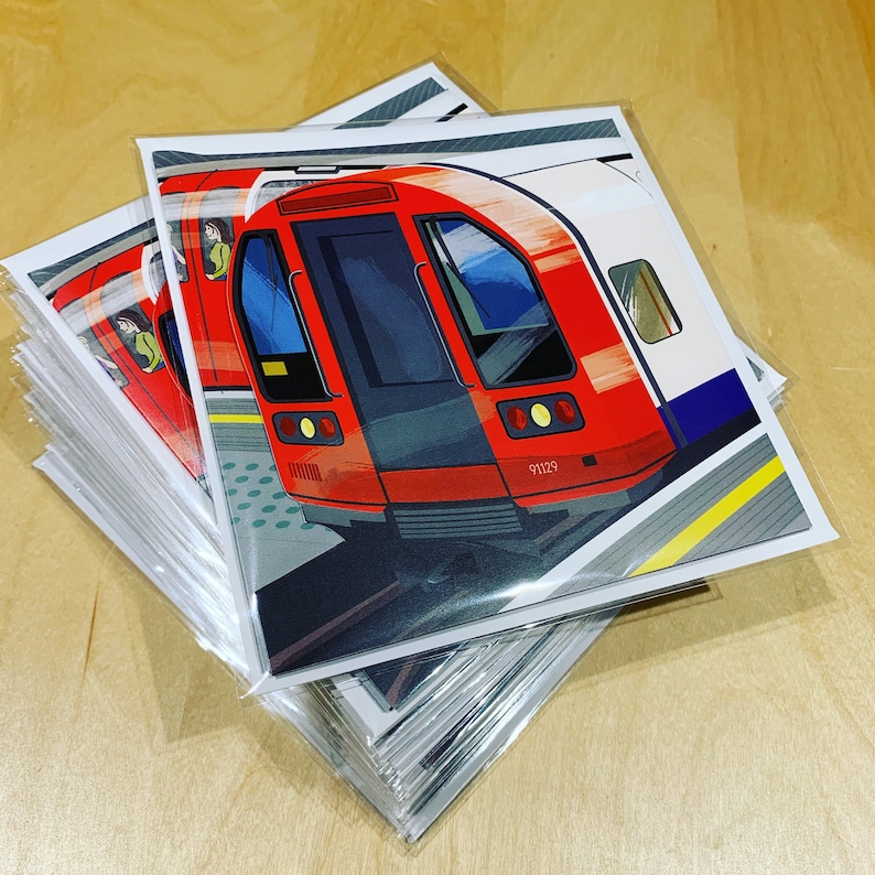 May include: A stack of blank greeting cards with a red and white London Underground train on the front. The train is labeled "91129".