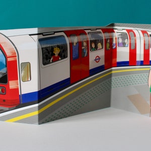 May include: A red and white London Underground train with passengers looking out the windows. Two people are waiting on the platform. The train is on a track with a yellow line and a gray platform.