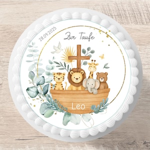 Könnte beinhalten: Ein runder Kuchen mit weißem Zuckerguss und dekorativem Rand. Der Kuchen zeigt eine Aquarellillustration von Tieren in einer Arche, ein Kreuz und den Text "Zur Taufe" und "Leo". Das Datum "28.09.2025" ist ebenfalls abgebildet.