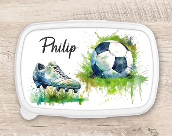 Könnte beinhalten: Weiße Lunchbox mit einem Aquarelldesign eines Fußballs und eines Fußballschuhs. Die Lunchbox trägt den Namen "Philip".