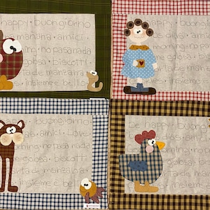 Può includere: Quattro arazzi da parete trapuntati colorati con uno sfondo a quadri verdi, rossi, marroni e beige. Ogni arazzo presenta un animale diverso e il testo "be happy, buongiorno, good morning, no pasa nada, golosa, biscotti, arta de manzana, insieme è bello".