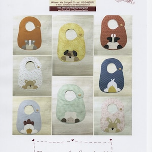 Può includere: Nove bavaglini per neonati con diversi disegni di animali. I bavaglini sono in tessuto e hanno un bottone giallo in cima. I bavaglini sono disposti in una griglia su uno sfondo bianco. Il testo "Pappe da favola 11" è in fondo all'immagine.