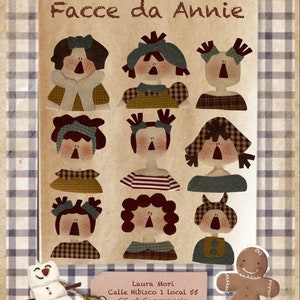 Puede incluir: Una colección de nueve caras de muñecas de fieltro de colores con diferentes expresiones, junto con un hombre de jengibre y un muñeco de nieve. Las caras están dispuestas en una cuadrícula sobre un fondo marrón con el texto "Facce da Annie" en la parte superior. El texto "Laura Mori" está en la parte inferior de la imagen, junto con la información de contacto.