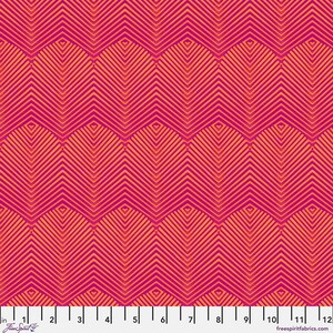 May include: A fabric swatch featuring a repeating geometric pattern of orange chevron lines on a vibrant magenta background. A white ruler at the bottom indicates a scale of 12 inches, with the text FreeSpirit and freespiritfabrics.com printed.