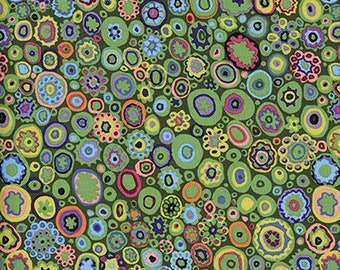 May include: A green fabric with a repeating pattern of colorful circles and dots. The circles are of various sizes and have different colored outlines and interiors.