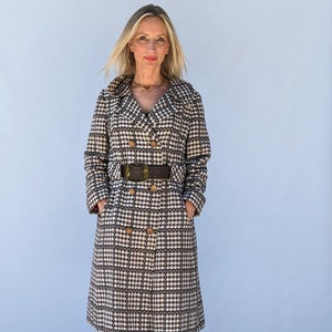 May include: A long, brown and white checkered coat with a brown belt and gold buttons. The coat has a double breasted closure and a collar.