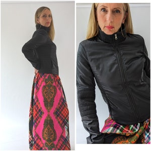 May include: A black zip-up jacket with a high collar and a pink and black patterned skirt.