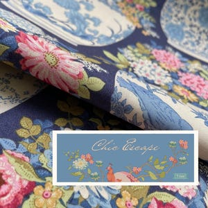 Könnte beinhalten: Ein marineblauer Stoff mit einem Blumenmuster aus rosa, gelben und weißen Blüten sowie blau-weißen Ziertöpfen. Ein rechteckiges Etikett ist überlagert und zeigt den Text Chic Escape und Tilda zusammen mit einer Pfauenillustration.