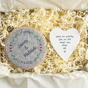 Puede incluir: Un aro de fieltro gris con bordado que dice "7 a&ntilde;os James & Melissa 14.6.2016" rodeado de una corona verde. Una placa de cer&aacute;mica blanca en forma de coraz&oacute;n con el texto "Loved you yesterday Love you still always have always will" tambi&eacute;n est&aacute; en la imagen.