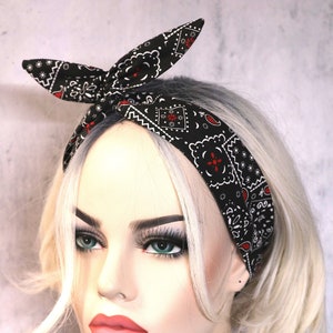 May include: A black and white bandana headband with a red paisley pattern. The headband is tied in a knot at the top of the head.