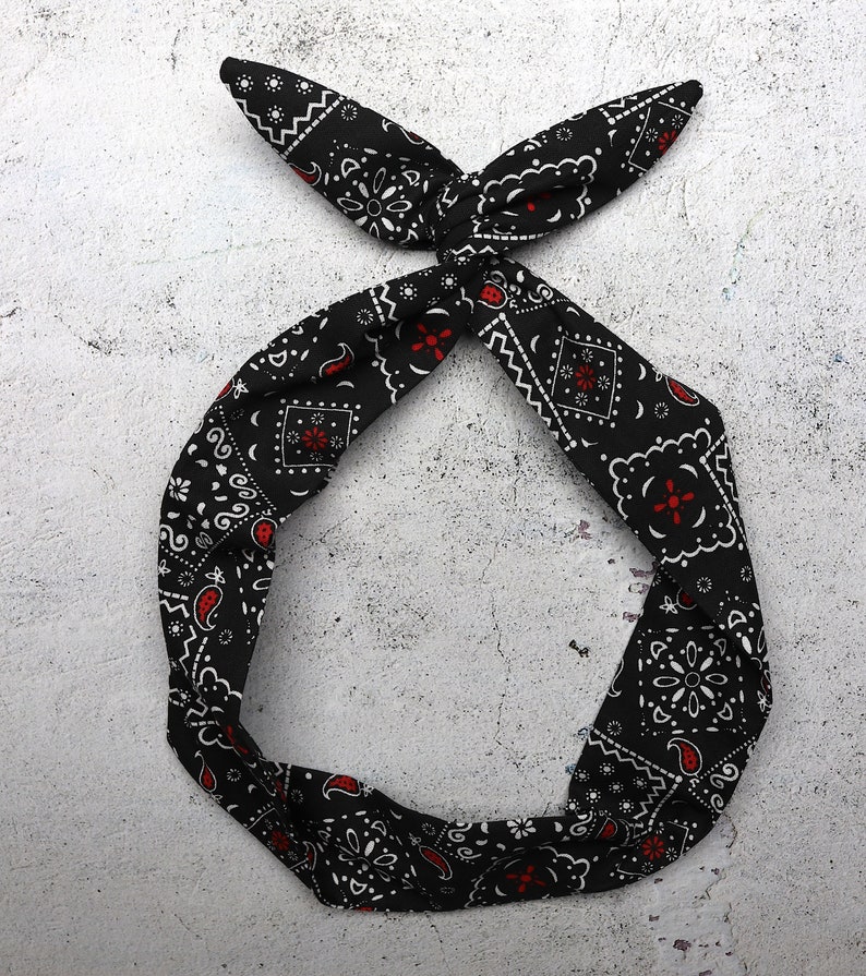 May include: Black bandana headband with a white and red paisley pattern.