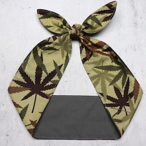 May include: A green and brown patterned headband with a grey fabric backing. The pattern features a repeating design of marijuana leaves.