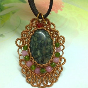 May include: A gold wire wrapped pendant with a green and black stone and pink and green beads.
