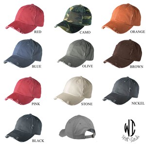 May include: Ten distressed baseball caps in various colors, including red, camo, orange, blue, olive, brown, pink, stone, nickel, and black. The caps have a distressed look with frayed edges and a slightly faded appearance. The caps are all the same style, with a curved brim and a small logo on the back.