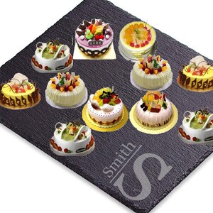Puede incluir: Surtido de diez pasteles decorados con diferentes coberturas de fruta, presentados en una bandeja de servicio de pizarra negra con la palabra "Smith" y una letra "S" estilizada grabada en la superficie.