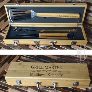 May include: A bamboo grilling tool set in a wooden carrying case. The case has a handle and is engraved with the text "Grill Master Matthew Kennedy".