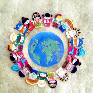 May include: A colourful felt world map surrounded by a circle of felt finger puppets representing different cultures. The puppets are wearing traditional clothing and have diverse facial features.