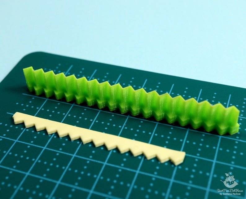 Może przedstawiać: Dwa plastikowe foremki do dekorowania ciast. Większa foremka jest zielona i ma falisty brzeg. Mniejsza foremka jest beżowa i ma podobny falisty brzeg.