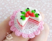 Miniature cake with strawberries on the knitted cloth for dolls and doll houses.