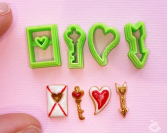 May include: Set of six green plastic cookie cutters shaped like a heart, key, envelope, and arrow.  The cutters are shown next to six decorated cookies in the shapes of the cutters.