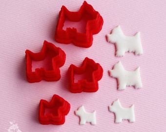 May include: Six red and white plastic cookie cutters shaped like dogs of different sizes. The cutters are on a pink background.