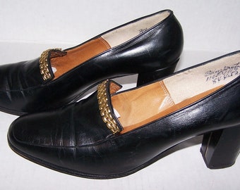 glamorous black chunky flat shoes with gold lion trim