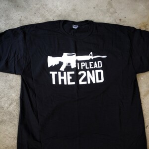 May include: Black t-shirt with a white silhouette of a rifle and the text "I PLEAD THE 2ND".