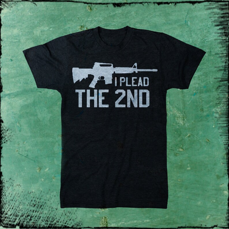 May include: Black t-shirt with a white silhouette of an assault rifle and the text "I PLEAD THE 2ND".