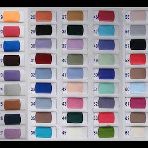May include: A fabric color swatch chart featuring eighty-one numbered rectangular samples arranged in three vertical columns. Each swatch displays a distinct solid color, ranging from neutrals and pastels to vibrant primary and secondary hues.