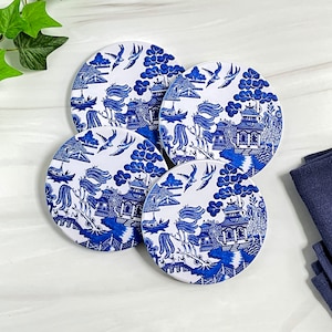 May include: Set of four blue and white ceramic coasters featuring a traditional Chinese willow pattern design.
